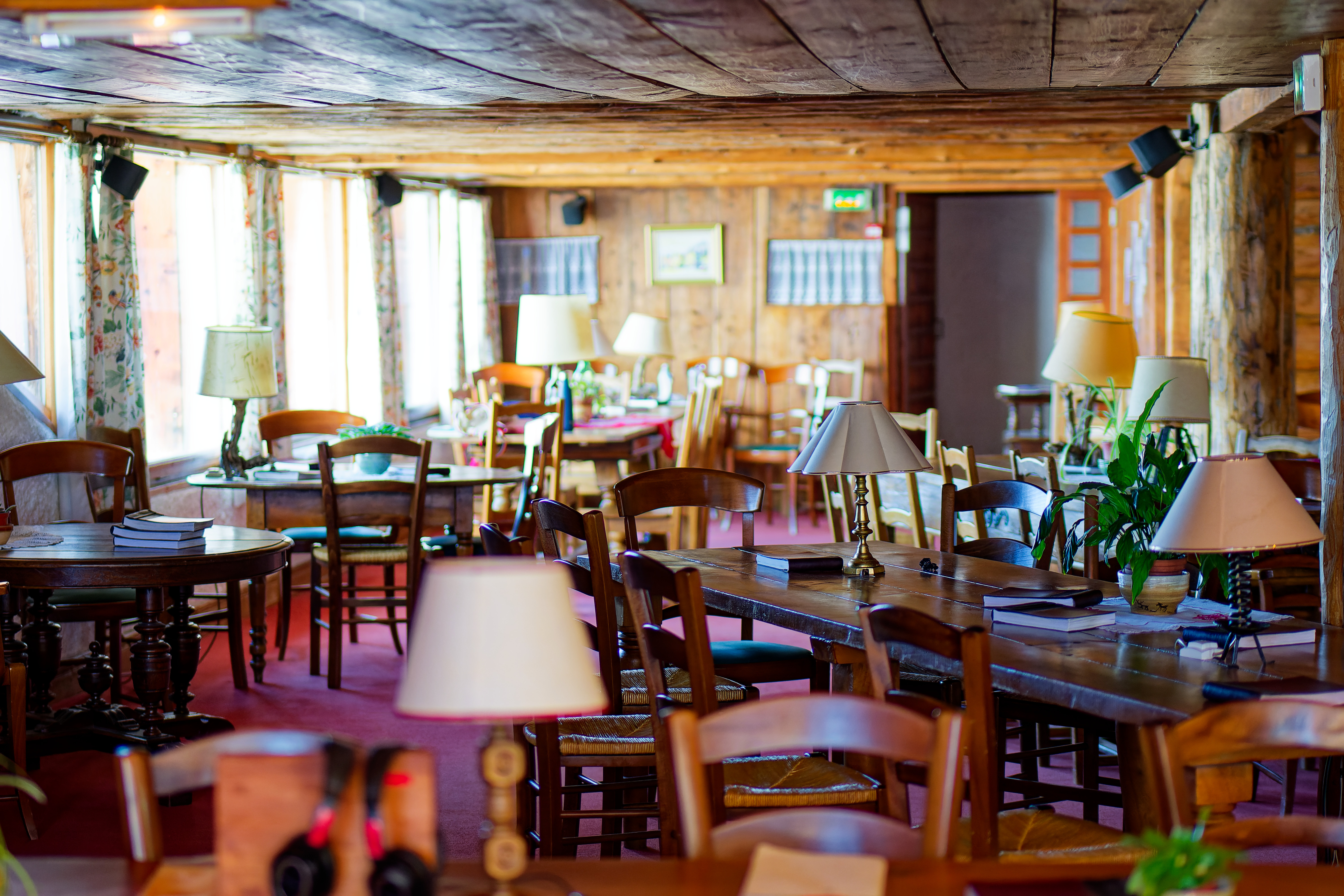 Salle commune chaleureuse avec tables et lampes